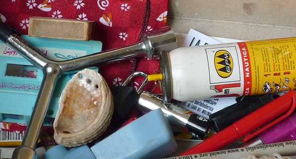 A photo of old useless objects, a cassette, a broken shell, a dead battery, an empty spray can, a plastic pen top, a broken pencil, etc.