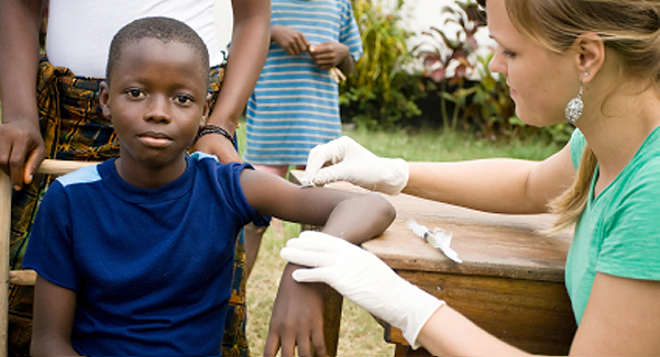 A photo of a health worker vaccinating children.