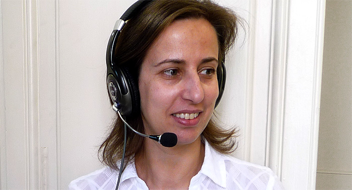 A photo of an online tutor, a woman wearing headphones and a microphone. 
