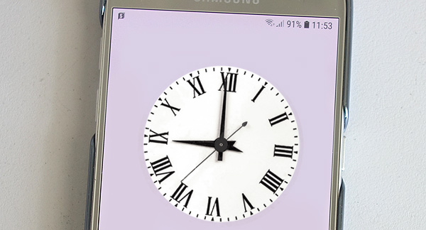 A photo of a antique clock face showing the time on a mobile. 