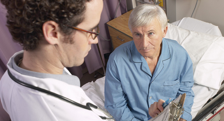 A photo of a doctor visiting a patient in his hospital bed.