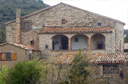 A photo of a large two-storey stone house in the country.