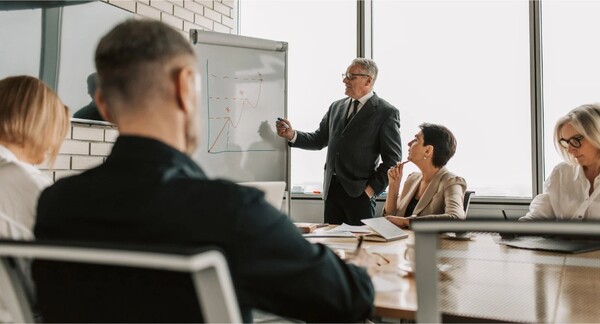 People in a business meeting, smiling and shaking hands.