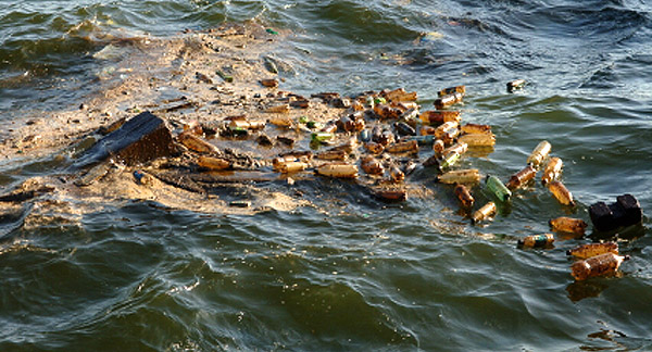 A photo of plastic bottles and other debris floating on the sea. 