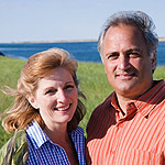 A photo of man and woman, with the sea in the background.