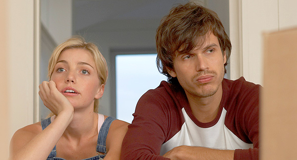A photo of a man and woman sitting at a table. They appear to be arguing or in disagreement about something.  