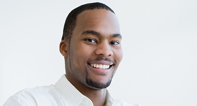 A photo of a young man with cropped hair and a beard. 